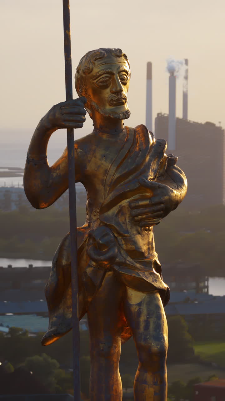 Aerial drone view of the golden statue atop a sphere on the Church of Our Saviour overlooking the Copenhagen skyline, with Frederik's Church dome in the background in Denmark. Vertical