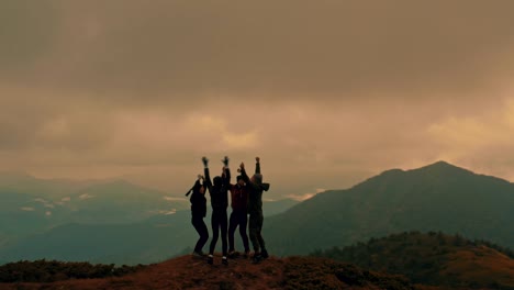 the four people jumping on a mountain top