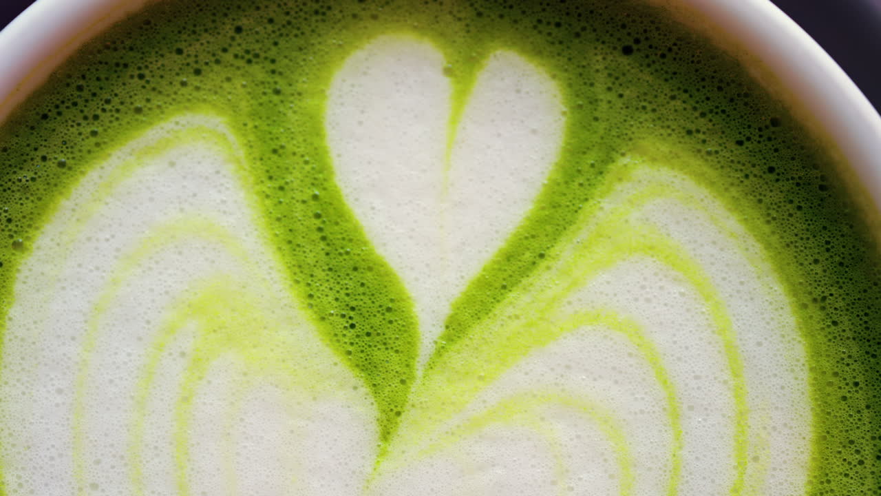 Close up of a matcha latte on a little green tray at a cafe