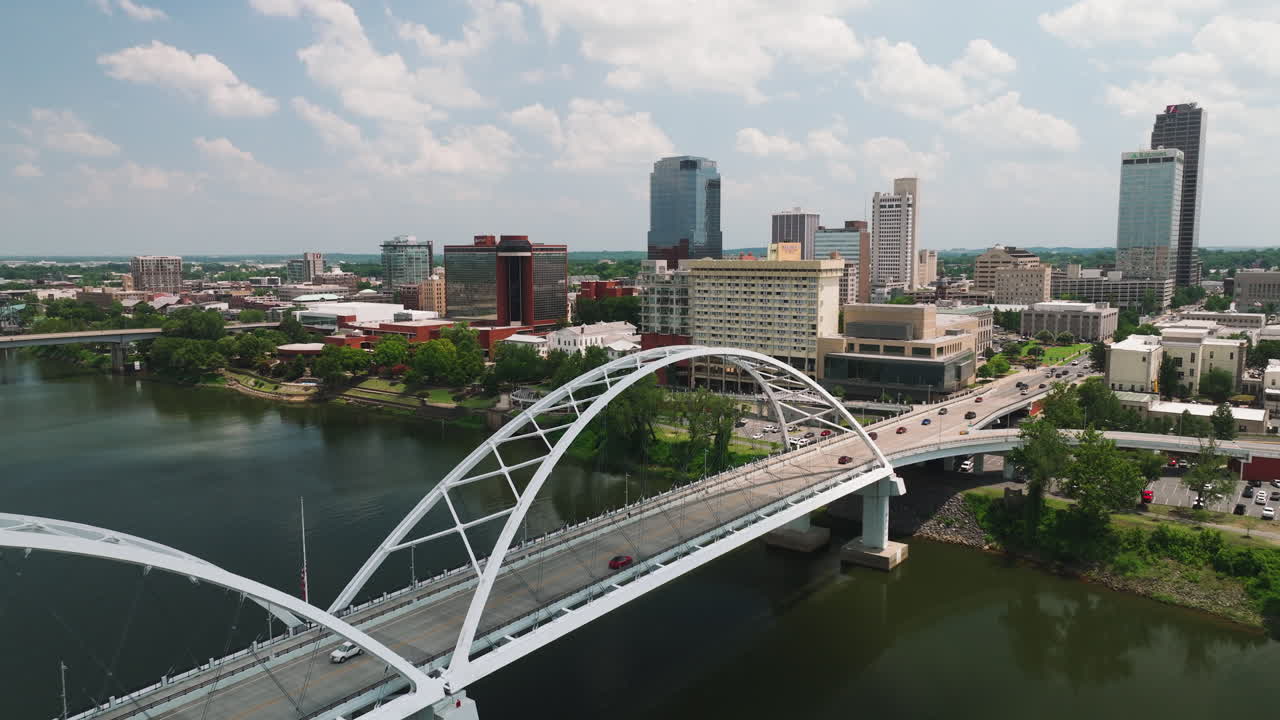 Flygfoto med uppåtlutning över Broadwaybron som korsar Arkansasfloden, stadssilhuetten i centrala Little Rock, Arkansas, USA.