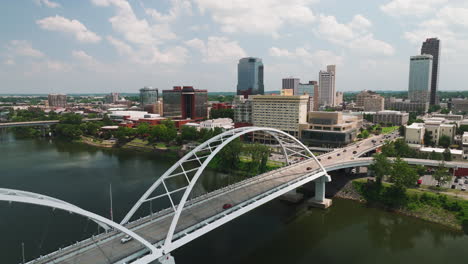 tilt-up aerial over broadway bridge crossing arkansas river, skyline downtown little rock, arkansas, usa