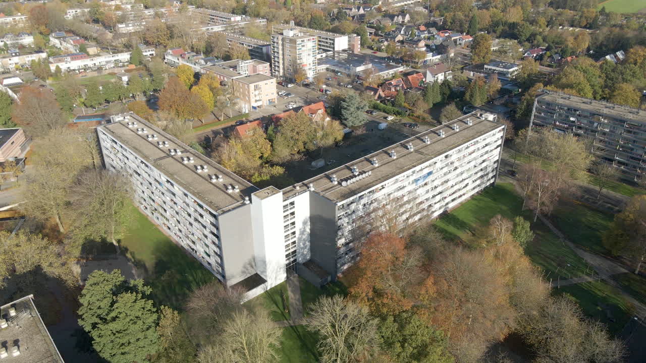 Jib down of social housing flat with green park in autumn