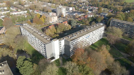 jib down of social housing flat with green park in autumn