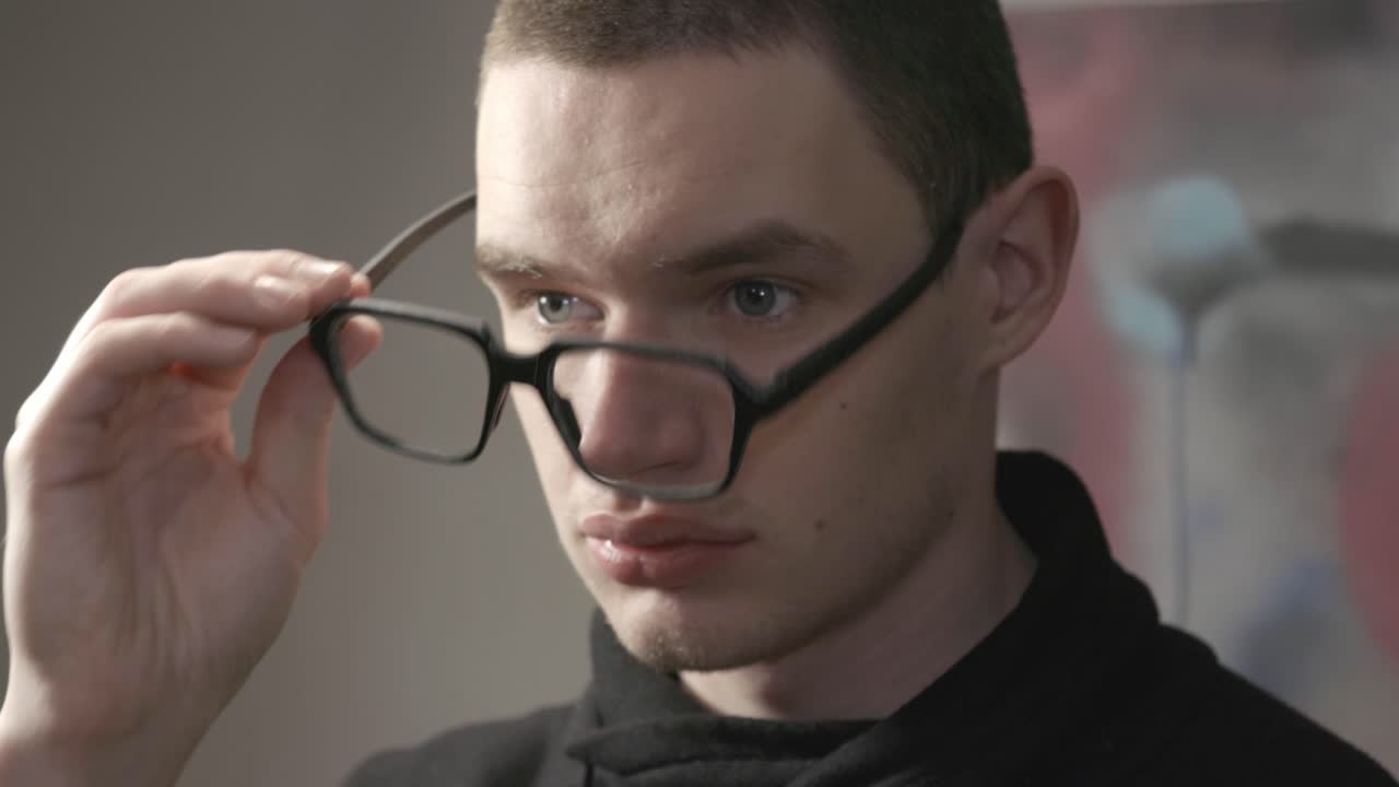 Attractive Young Man Putting On Eye Glasses And Afterwards He Remove.- closeup shot