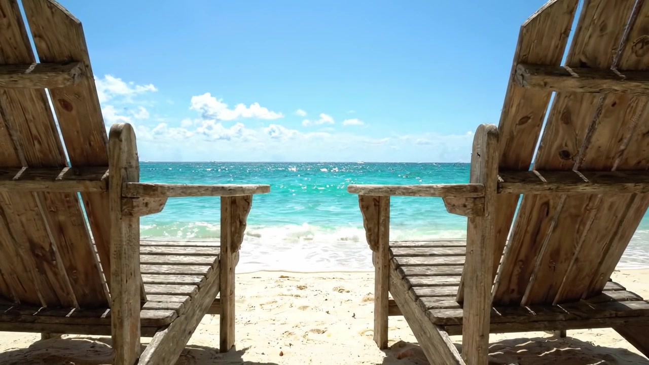Ruhiger Rückzugsort am Strand: Zwei rustikale Stühle laden zur Entspannung ein, mit Blick auf den kristallklaren Ozean unter einem strahlend blauen Himmel