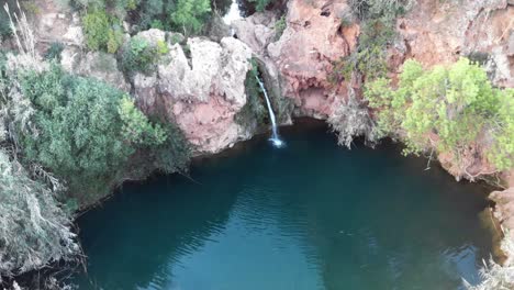 Cascada-De-Pego-Do-Inferno-Y-Lago-Turquesa-En-Tavira,-Algarve,-Portugal---Antena-De-Punto-De-Interés-Orbital