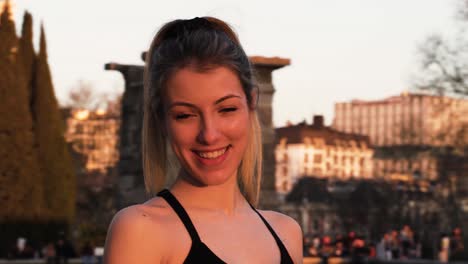 beautiful young female smiling and laughing at camera in urban park