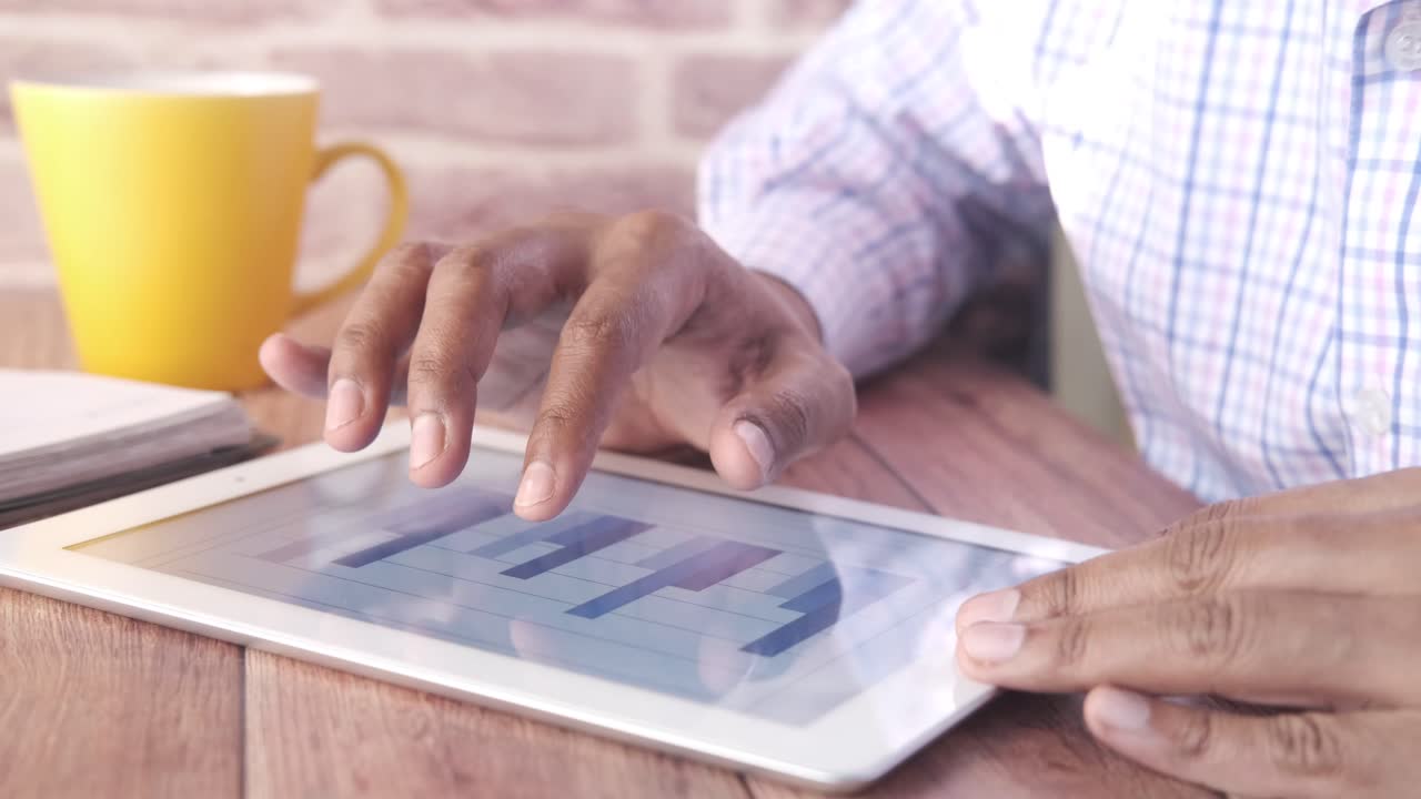 Person using a tablet with graphs and charts