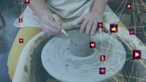 Animation of network of connections with icons over caucasian woman doing pottery