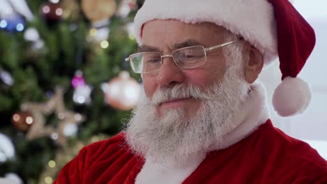 santa claus sitting and laughing while reading a funny book