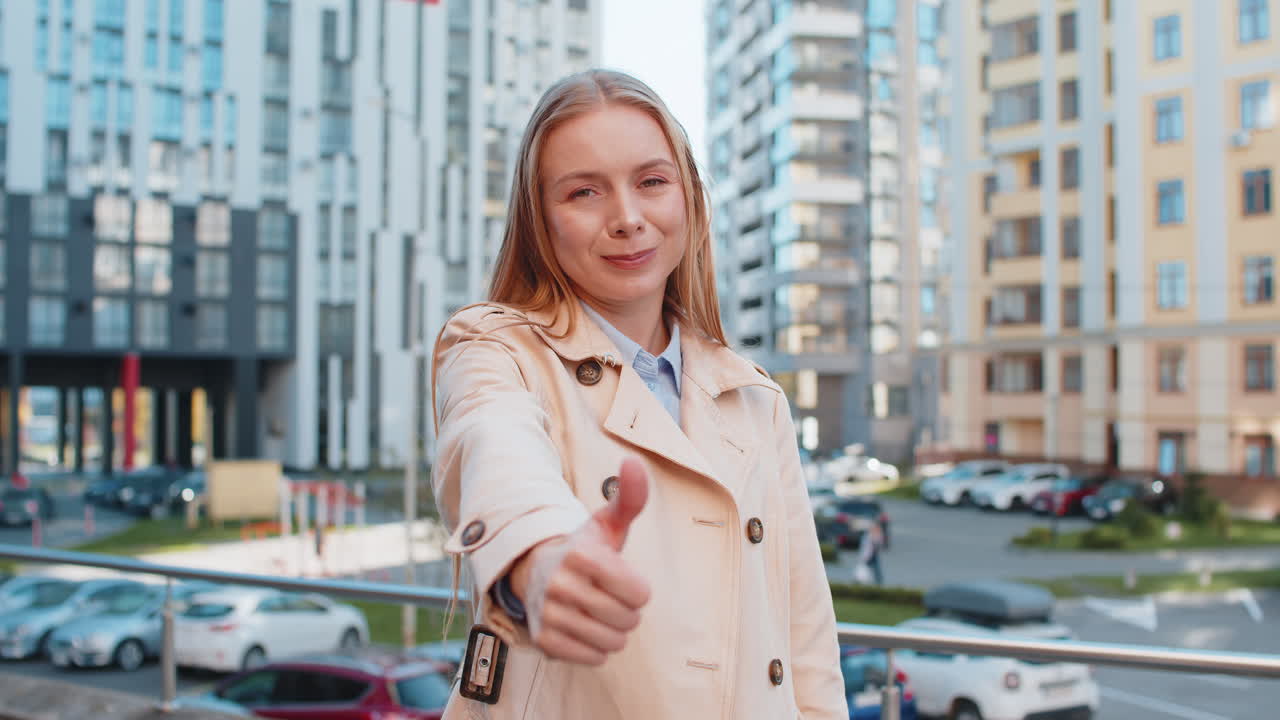 Happy mature caucasian woman showing thumb up gives positive reply standing on downtown city street