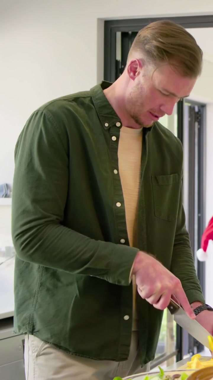 Vertical video: Slicing yellow pepper, man in green shirt going to table, serving guests for dinner