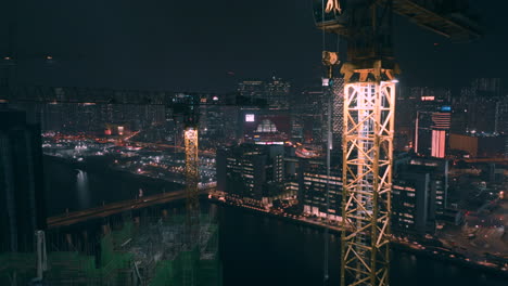 drone shot approaching a yellow construction crane on top of residential construction with worker climbing down ladder