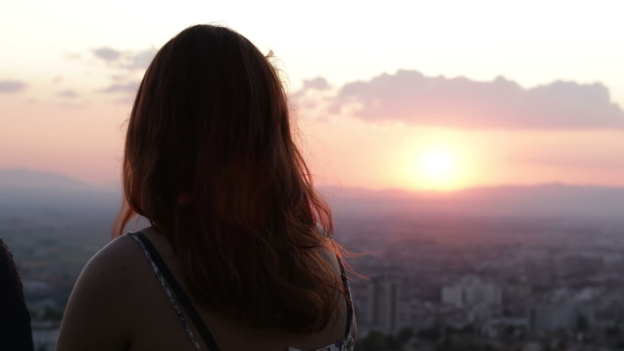 Woman watching sunset over the city