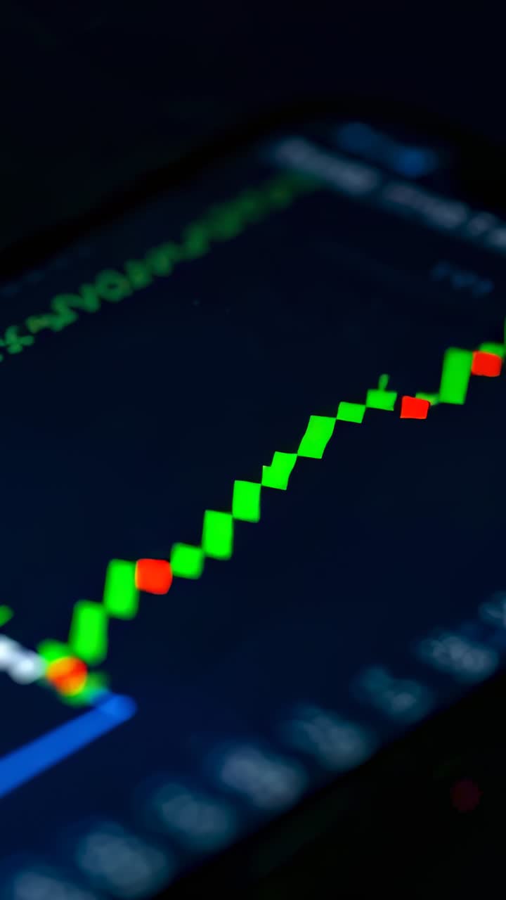 Vertical video: Updating app chart as tick hitting phone at desk, showing green candles, blue trend