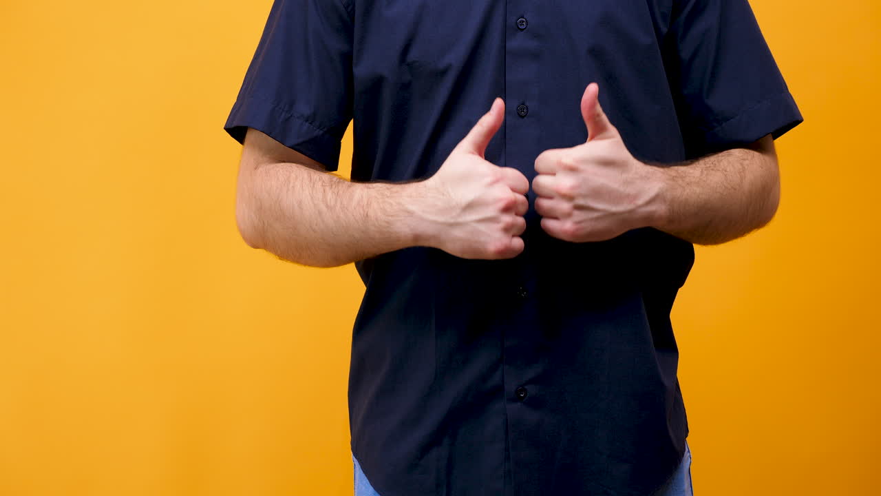 Man giving a thumbs up on a yellow background