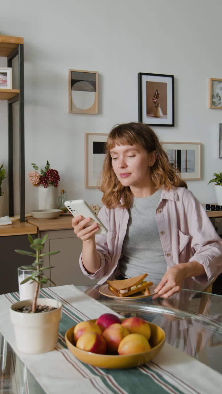 Woman with sandwich and fruit at the table
