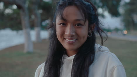 happy asian girl smiling at camera outdoors