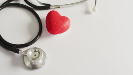 Video-of-close-up-of-stethoscope-with-heart-on-pink-background