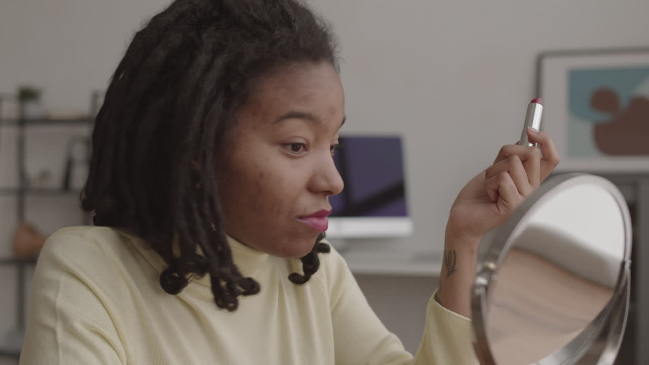 Young African Woman Applying Beautiful Lipstick