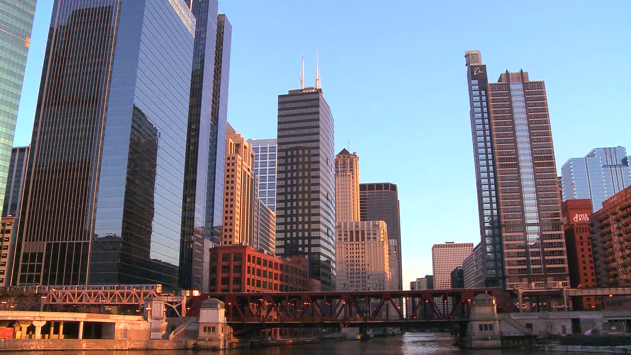 el 열차는 시카고 스카이라인 앞의 다리 위를 여행합니다.