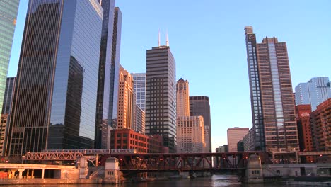 the el train travels over a bridge in front of the chicago skyline
