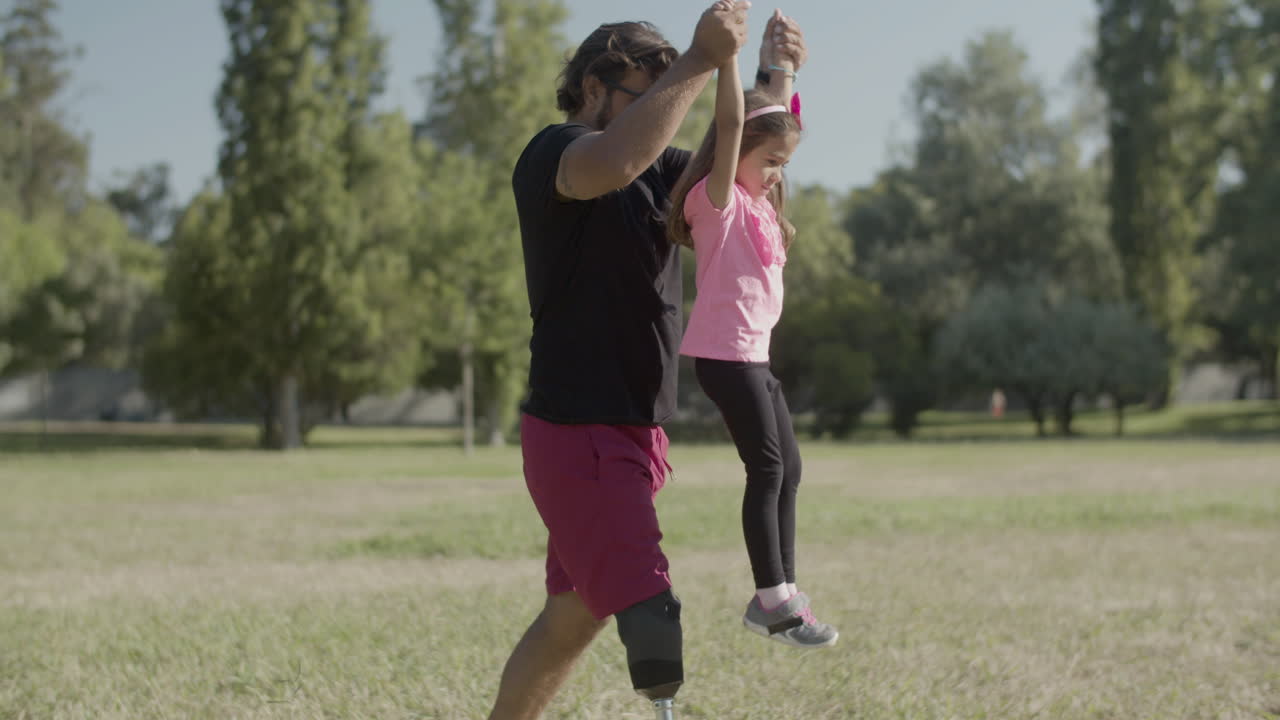 tomada de seguimiento de un padre con discapacidad levantando a su hija con las manos