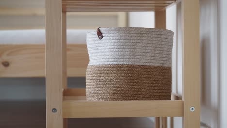 stylish woven basket on wooden shelf