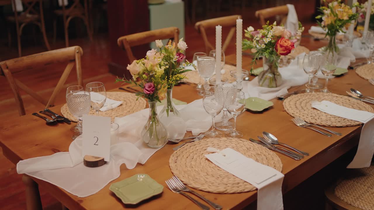 Elegante arreglo de mesa con flores, velas y cristalería para cena de evento