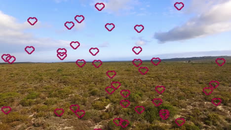 Hearts-animation-over-vast-landscape-with-greenery-and-blue-sky