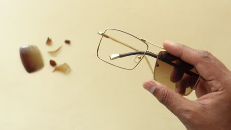 a person holding broken sunglasses