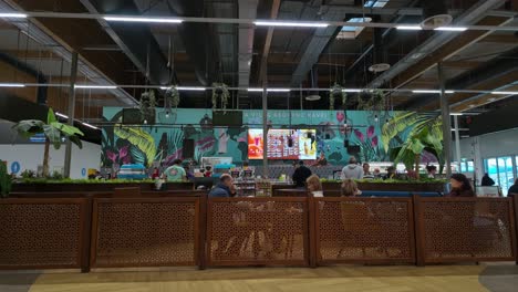 travelers relax at the cafe frei cafeteria, of which background design depicts the variety of favorite coffees from all over the world at the liszt ferenc airport, budapest, hungary.
