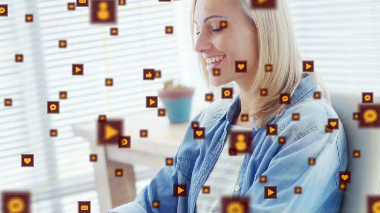 Sitzende Frau tippt am Laptop, wodurch Herz-, Kommentar- oder Wiedergabe-Symbole am Gesicht vorbeischweben, zur Markenförderung.