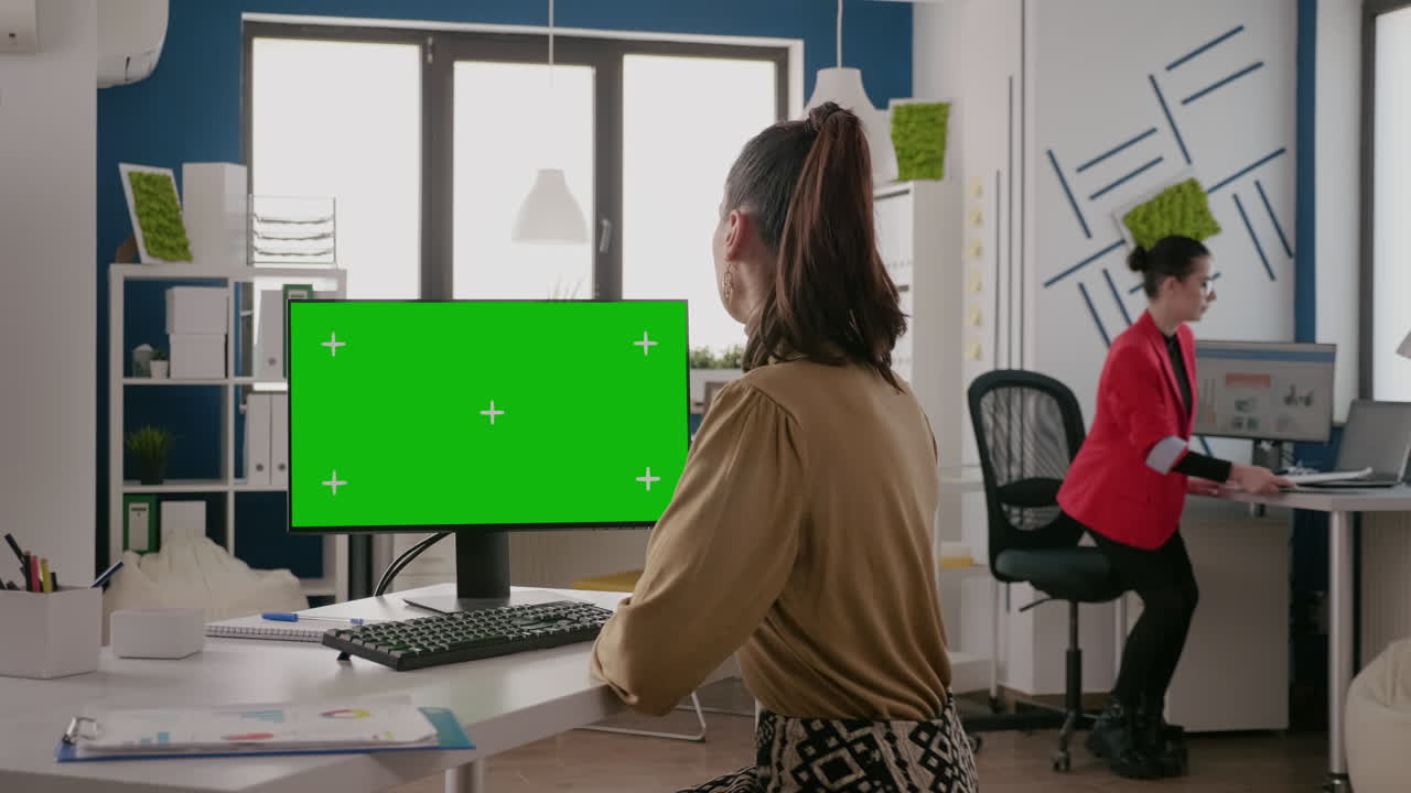 Adult working on computer with green screen