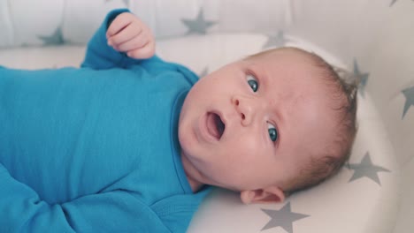 playful-little-boy-shows-tongue-resting-in-modern-cocoon