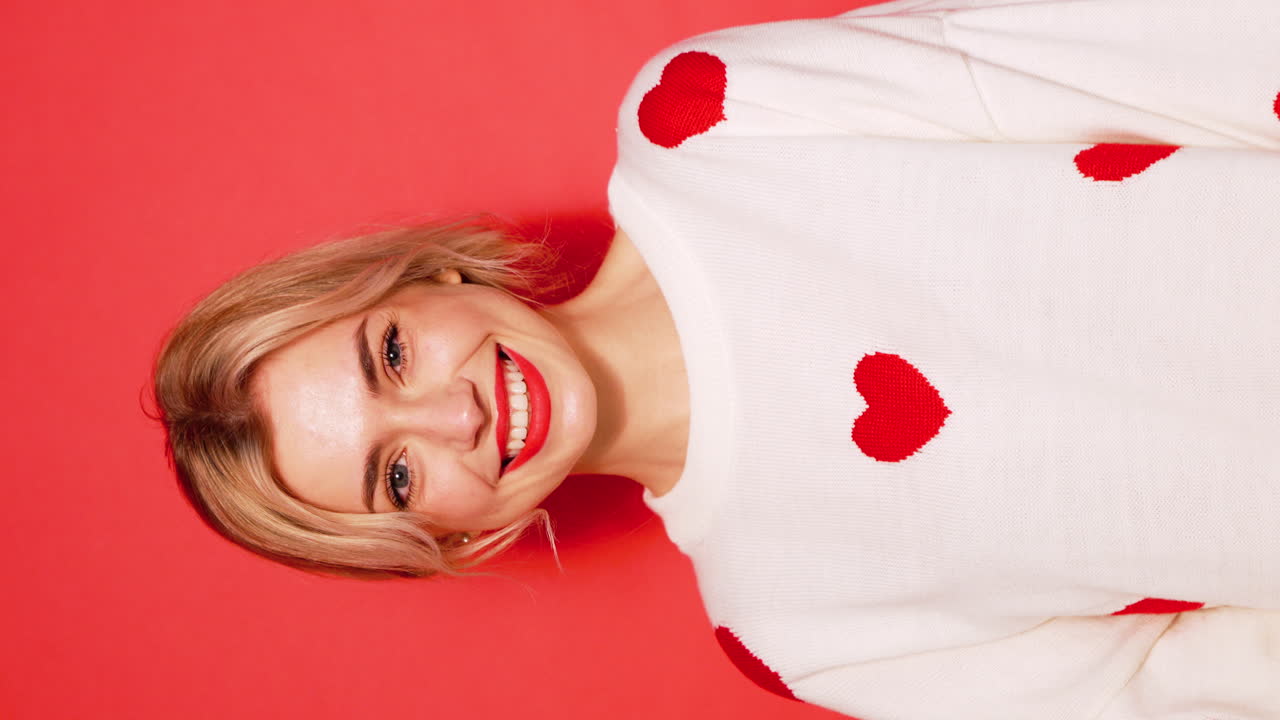 심장 스웨터를 입고 미소 짓는 여자