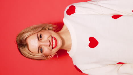 mujer sonriendo con un suéter de corazón