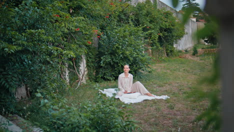 beautiful lady relaxing picnic blanket in garden. woman sitting green grass park