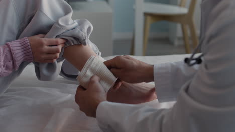 doctor applying bandage to patient's arm