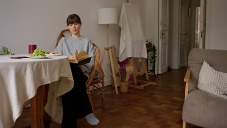 woman reading book during breakfast at home