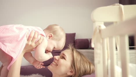 madre feliz sosteniendo al bebé en las manos