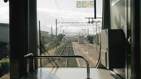 view from the glass window of traveling train on railroad at sunny day in sendai, japan