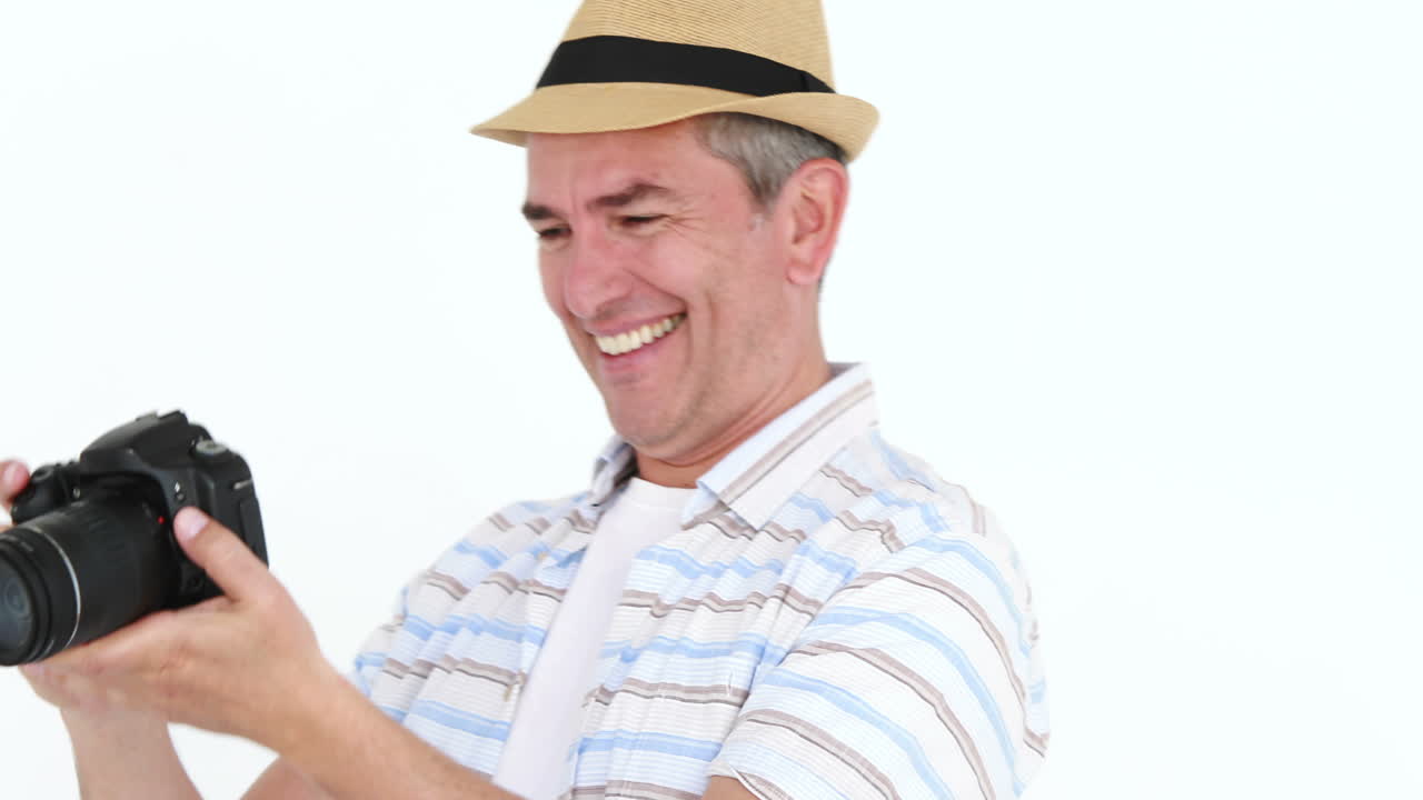 디지털 카메라로 사진을 찍는 미소 짓는 남자