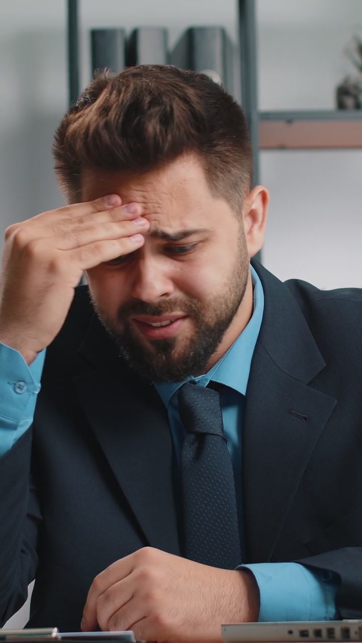 Stressed businessman work at unpaid bank debt doing paperwork planning budget throws paper bills