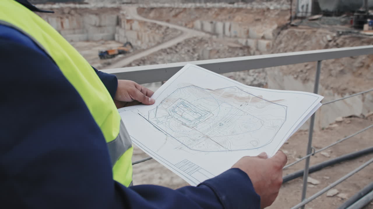 Unrecognizable Quarry Worker with Blueprint