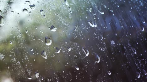 Bucle-Interminable-Y-Continuo-De-Una-Ventana-Llena-De-Gotas-De-Agua-Y-Condensación-Con-Un-Entorno-Natural-Fuera-De-Foco-Detrás-De-Ella.-Clima-Melancólico,-Nostálgico,-Nublado,-De-Mal-Humor,-Con-Niebla.