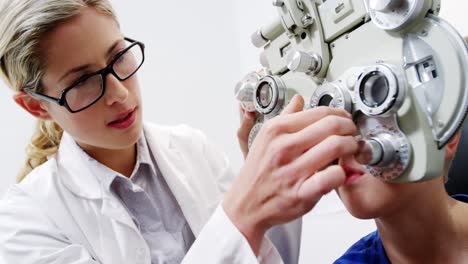 una optometrista examinando a un paciente joven en quiroptero