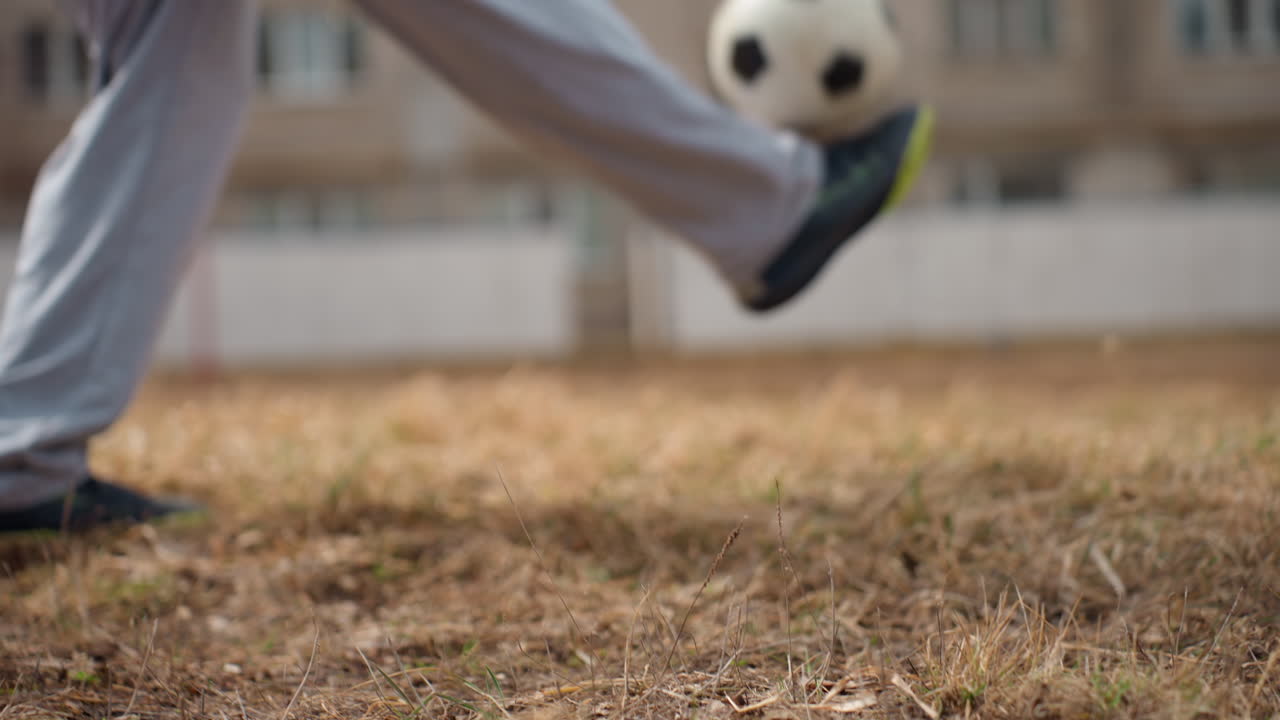 축구 경기 중 발이 공에 닿는 모습, 클로즈업으로 발차기 동작을 보여주며, 발이 공과 닿는 순간을 자세히 묘사하고, 발 컨트롤과 잔디밭 위 공의 충격을 포착한 섬세한 장면