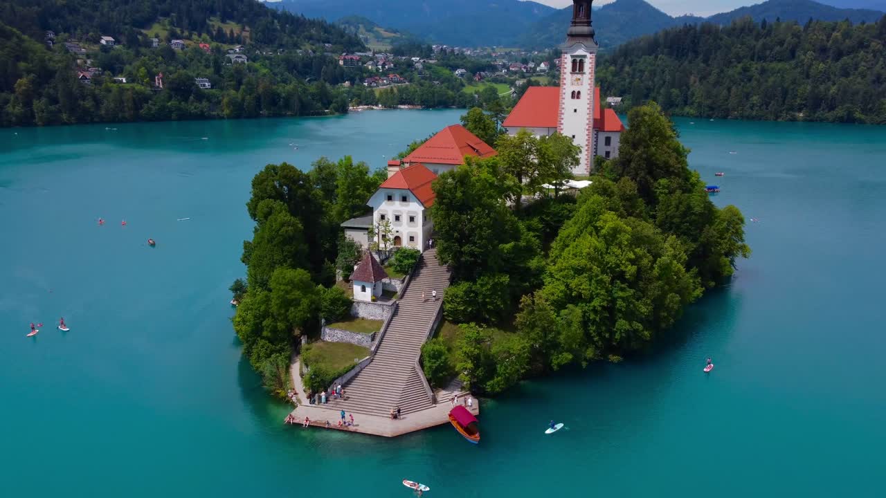 4K Aerial drone video of Lake Bled Island and Church of the Assumption of Mary on a quiet sunny summer morning - Bled, Slovenia