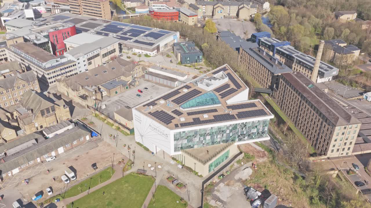 University of Huddersfield Queensgate Campus in Huddersfield Kirklees West Yorkshire mit modernen Gebäuden, angrenzenden historischen Mühlenstrukturen und markantem Schornstein nahe dem Huddersfield Narrow Canal.